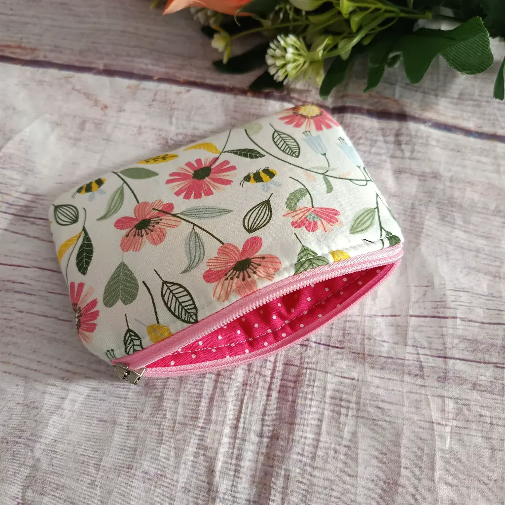 pequeño monedero básico de mujer confeccionado en tela blanca con diseño de flores