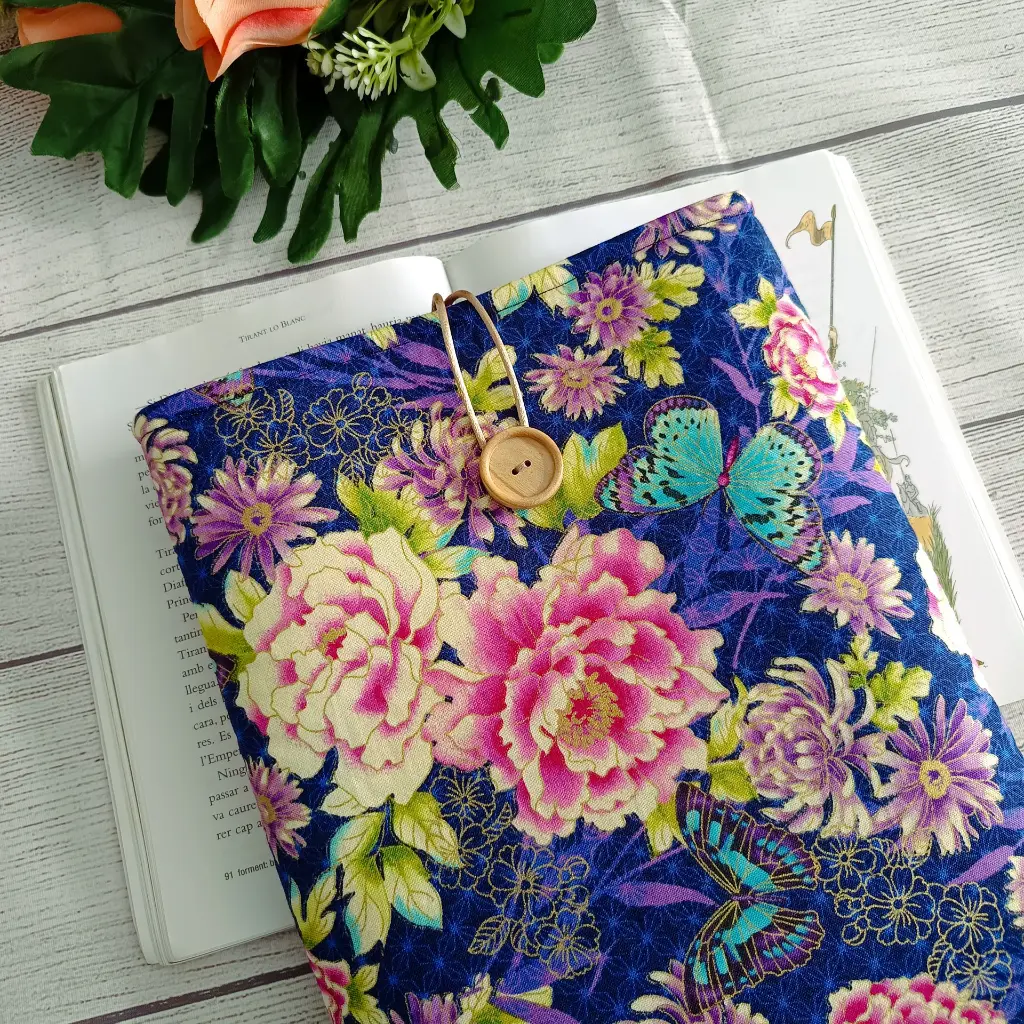 funda de libro de tela azul con flores y mariposas hecha a mano