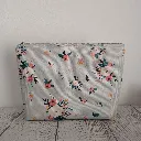 Detalle del tejido impermeable y cremallera resistente del neceser organizador de cosméticos con diseño botánico.