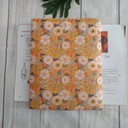 Funda de libro artesanal con estampado floral en tonos amarillos y cierre con botón, interior suave rosa