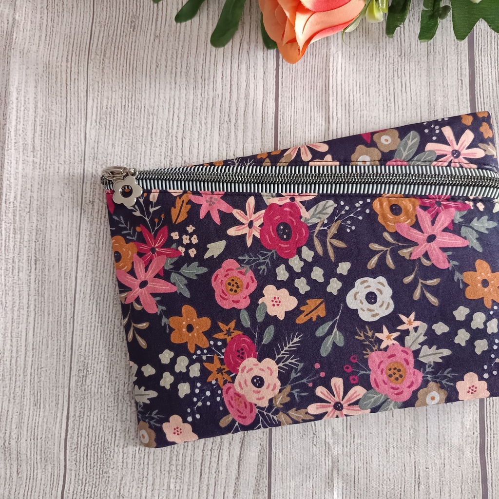 Neceser plano hecho a mano con cremallera y estampado floral sobre fondo azul marino