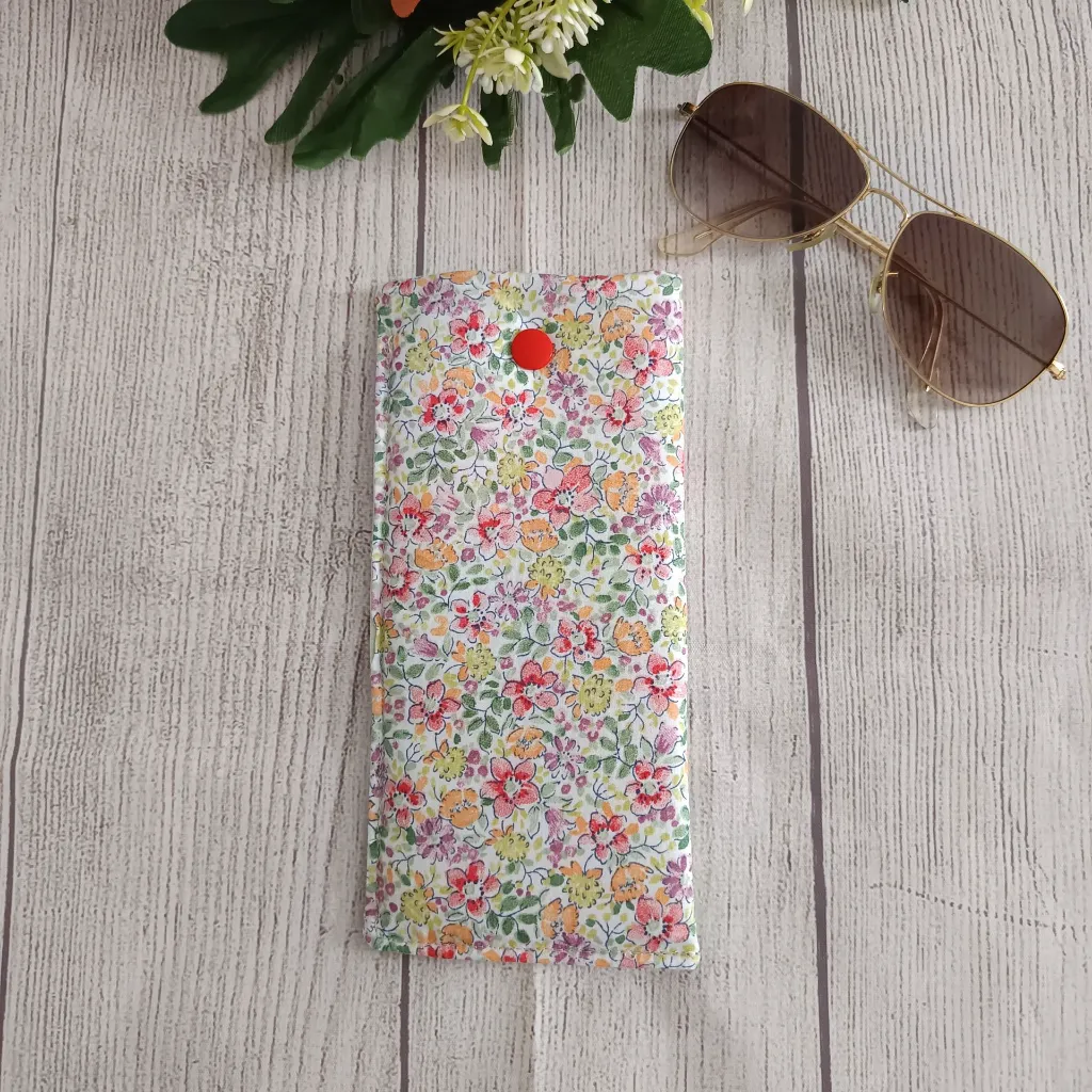 dentroFunda de gafas artesanal en tela floral multicolor abierta con gafas de sol en su interior