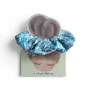 Coletero artesanal hecho a mano con tela floral en tonos azules y rosas sobre fondo blanco