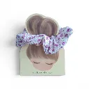 Coletero artesanal hecho a mano con tela floral en tonos  lilas sobre fondo blanco