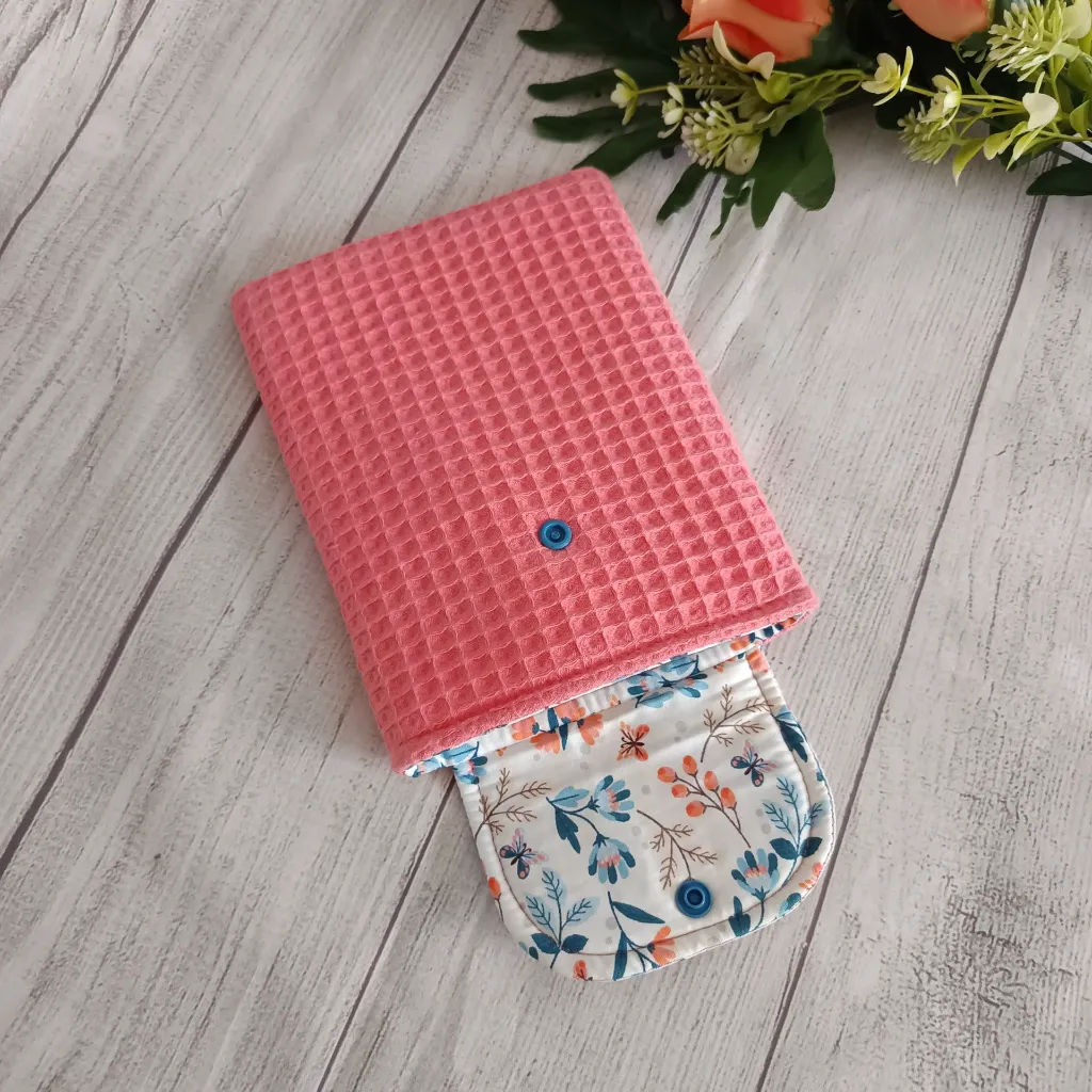 Funda kindle hecha a mano abierta mostrando el interior y la solapa floral con cierre a presión azul