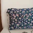 Bolso de tela artesanal con estampado floral y cadena metálica.