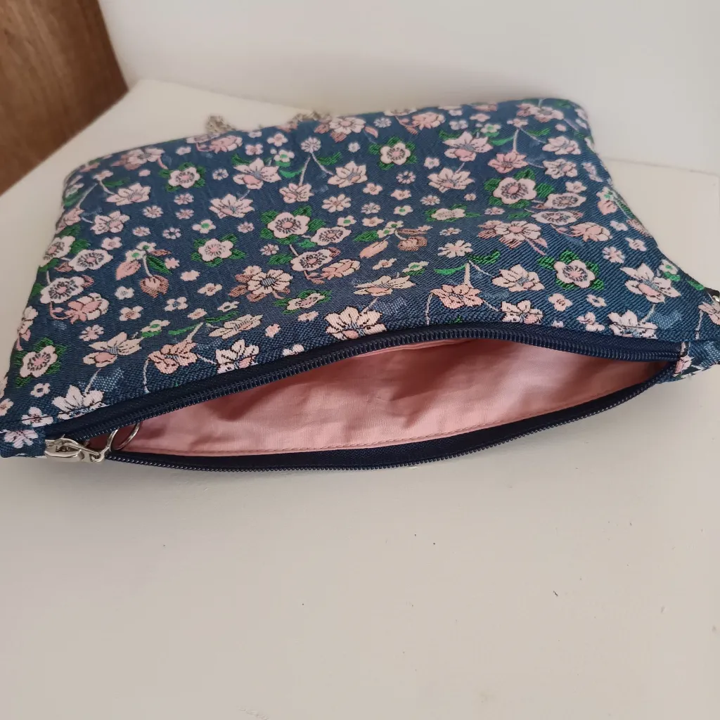 Bolso de tela azul con flores usado como bolso de hombro.