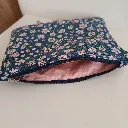Bolso de tela azul con flores usado como bolso de hombro.