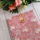 Estuche para libro artesanal de tela rosa con estampado floral y cierre de botón de madera.
