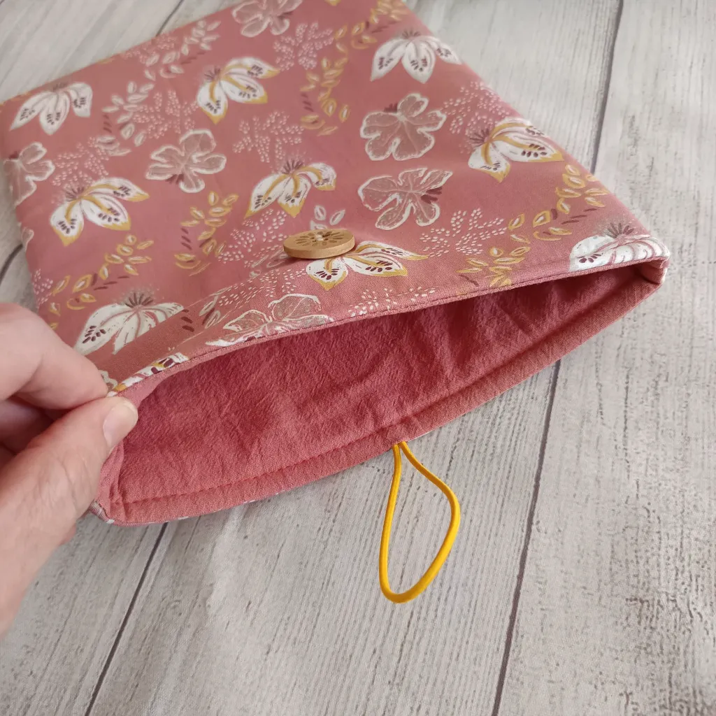 Estuche para libro acolchado en tela estampada rosa, ideal para proteger novelas, agendas y cuadernos.
