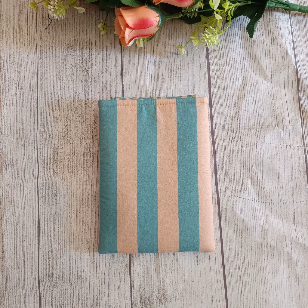 Funda Kindle acolchada artesanal de rayas turquesa y beige con cierre de botón.