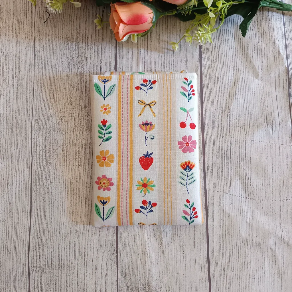Funda para Kindle hecha a mano con flores de colores y rayas sobre fondo beige.
