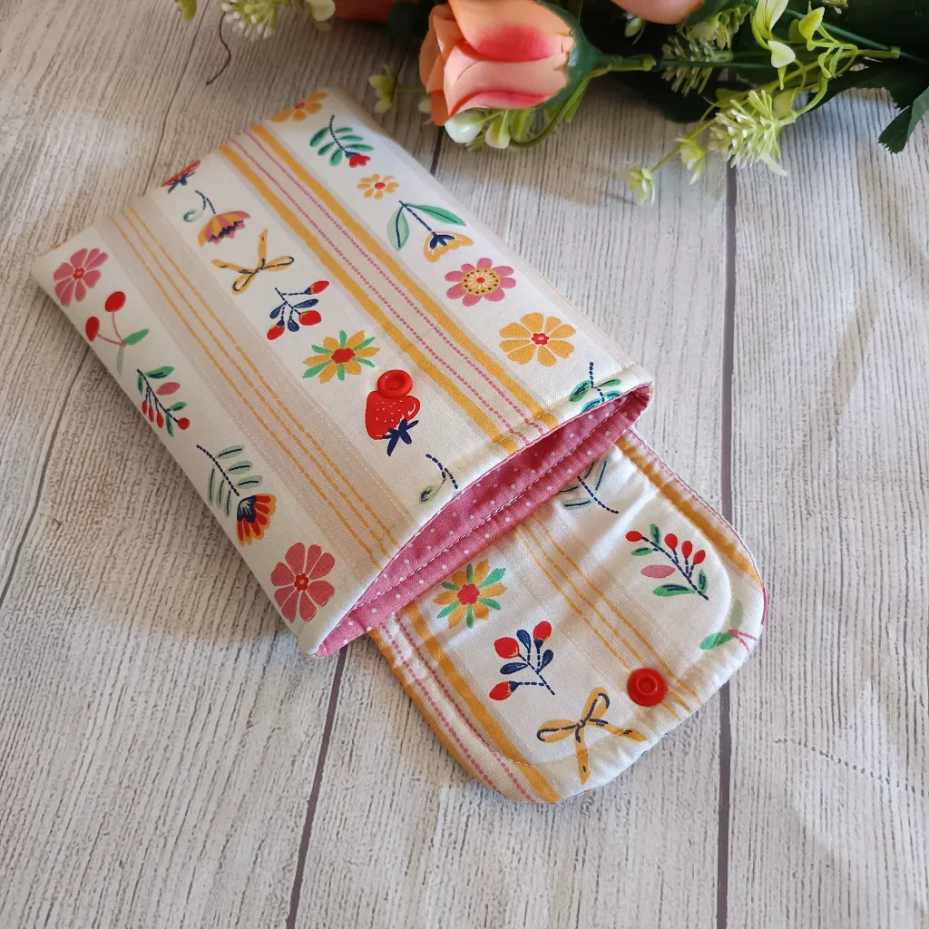 Funda Kindle acolchada con estampado floral y detalles en rojo, amarillo y rosa.