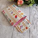 Funda Kindle acolchada con estampado floral y detalles en rojo, amarillo y rosa.