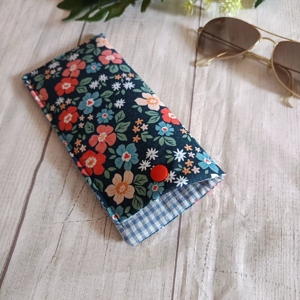 Detalle des estampado  floral en funda de gafas de tela ,flores rojas y azules